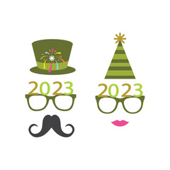 Party glasses and greetings decorated with a hat and stars in green, ready to be used in New Year's Eve party for 2023.