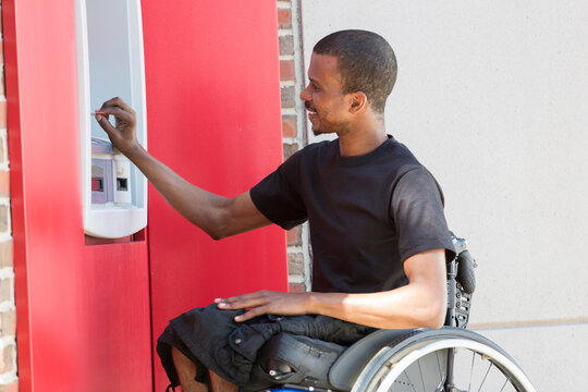 Man who had Spinal Meningitis in a wheelchair at a bank ATM