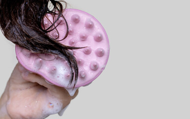silicone shampoo brush with soft bristles and woman brunette dark hair with foam isolated mock up...