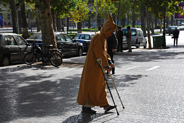 Hombre anciano paseando con muletas.