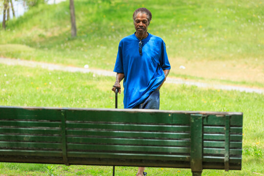 Man with Traumatic Brain Injury taking a walk with his cane in a park