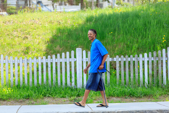 Man with Traumatic Brain Injury relaxing with his cane in his neighborhood