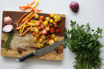Tomatoes, onion, peppers and parsley on cutting board