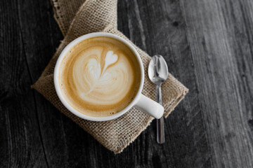 Heart design latte in mug on burlap