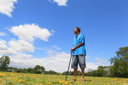 Man with Traumatic Brain Injury taking a walk with his cane in a park