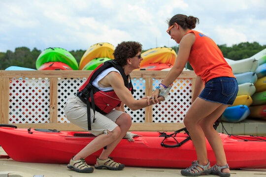 Instructor helping a woman with a Spinal Cord Injury get into a kayak