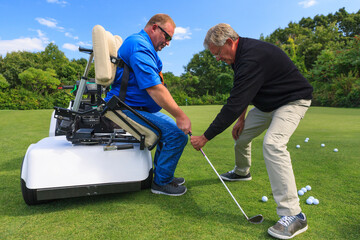 Man with spinal cord injury in an adaptive cart at golf putting green with an instructor