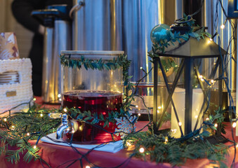 Christmas garlands and lights and candle, glass decanter with mulled wine