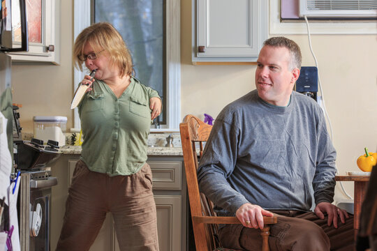 Woman with TAR Syndrome picking up a knife with her husband in the kitchen