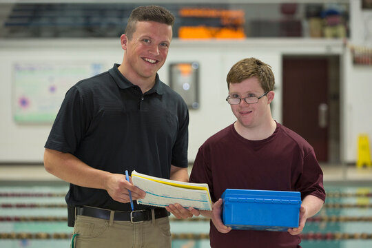 Young man with Down Syndrome working at college recording PH from swimming pool