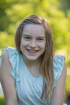 Portrait of happy Hispanic teen girl with braces in park