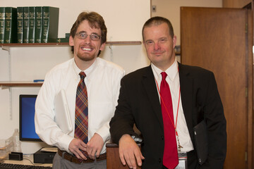 Portrait of man with Down Syndrome smiling with a collaborator in the State Capitol office