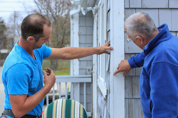Homeowner communicating with home repair man in American Sign Language, saying 'White'