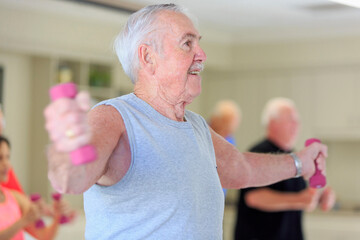 Happy senior man exercising in gym