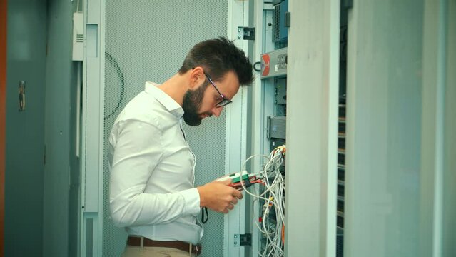 IT administrator present in mining server room, connecting an Ethernet wire