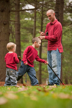 Father signing to his son as they play in the park in autumn