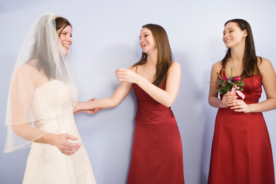 Cheerful young bride standing with bridemaids.