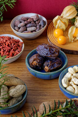 Assortment of healthy snacks: fruits and nuts on winter decorated table.