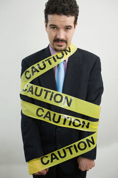 Portrait of a businessman wrapped in a Caution tape