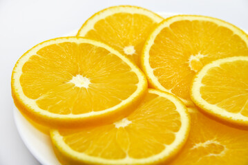 Sliced orange slices on a white plate. Orange slices on a white background. Oranges close-up.
