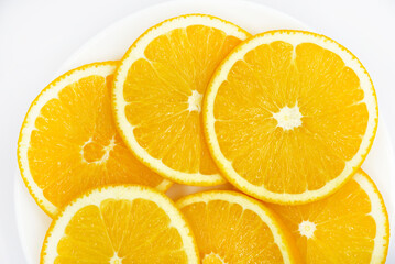 Sliced orange slices on a white plate. Orange slices on a white background. Oranges close-up.