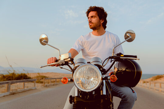 young couple on motorcycle on a road traveling to the beach