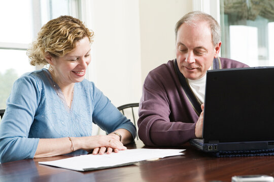 View of a mature couple discussing by table.