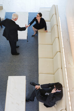 Elevated view of businesspeople shaking hands in an office.