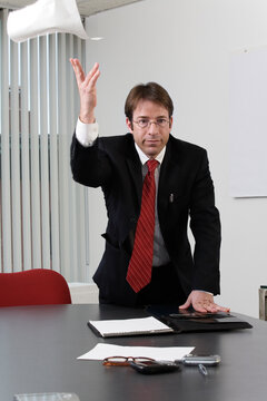 Portrait of a business man throwing paper.