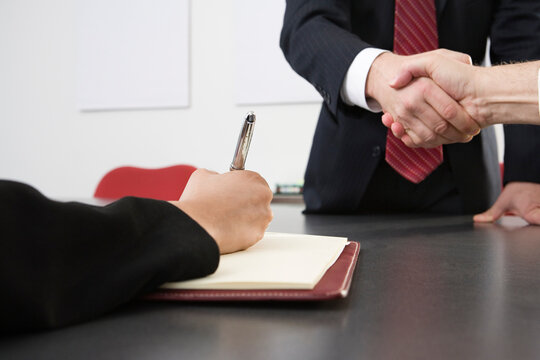 Midsection of business men shaking hands at an office.