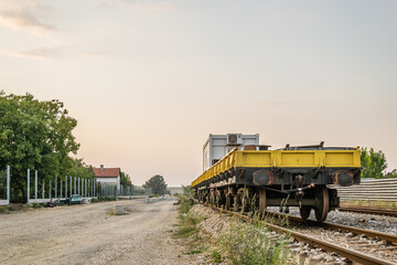 Empty working freight car on railway tracks. Concrete sleepers for the installation of a new railway through the town of Petrovaradin. Vojvodina, Novi Sad, Serbia.