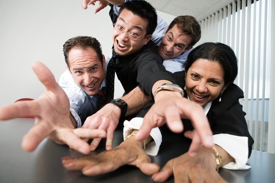 View of businesspeople grabbing on to a desk.