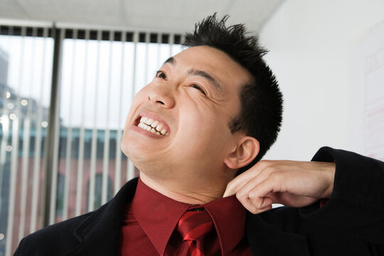 View of a mid adult man adjusting his collar.