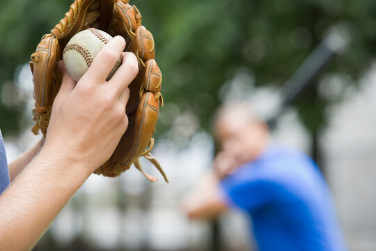 Close-up of a person's hand wearing a baseball glove and holding a ball