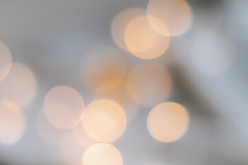 Yellow bokeh effect on a light background. Bokeh background from a garland. Abstract Blurred Christmas Lights Bokeh Background