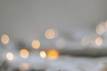 Yellow bokeh effect on a light background. Bokeh background from a garland. Abstract Blurred...