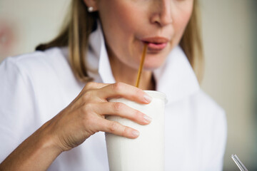 View of a woman drinking milkshake.
