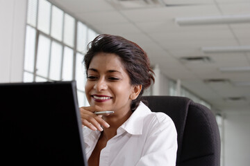 A business woman looking at a laptop.