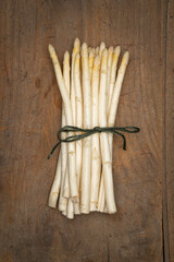 White asparagus tied in a bunch on an old farmers table
