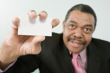Portrait of a businessman holding a blank business card