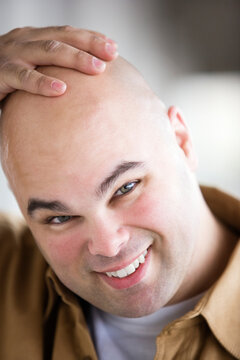 Portrait of a bald headed man smiling .