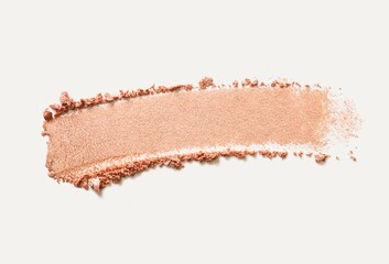 Cosmetic texture bronzer pressed powder smudge with shimmer isolated on light beige background