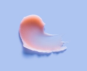 Cosmetic lip balm, salt or sugar scrub orange swatch on purple background