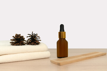 Natural cosmetics with cosmetic oil. Fir cones and white towel.