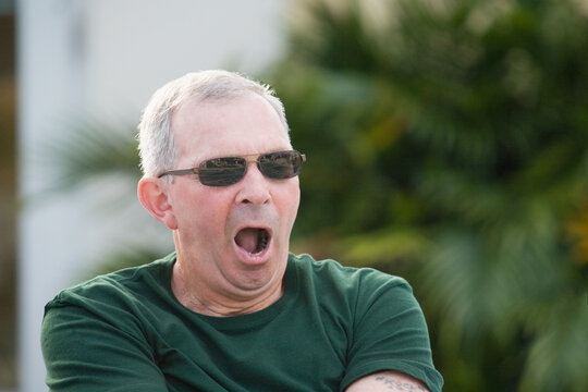 Close-up of a senior man yawning