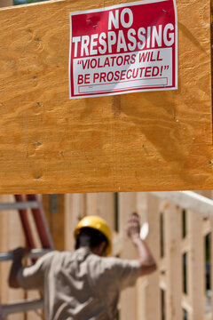 No Trespassing, Violators Will Be Prosecuted sign on wood beam during construction