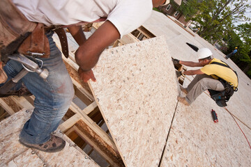 Carpenters putting a particle board in place