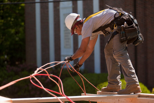Carpenter untangling power cord at a construction site