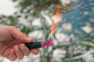 Burning Firecracker in a Hand. Guy Holding a Petard Outdoors in Winter at Daytime. Loud and...