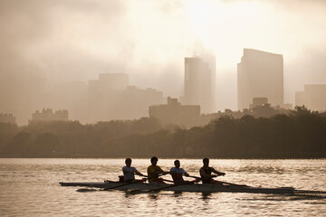 People rowing a boat in a river with city in the background, Charles River, Back Bay, Boston, Massachusetts, USA
